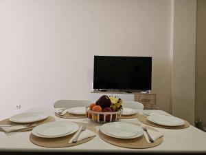 einen Tisch mit Tellern und eine Schale Obst darauf in der Unterkunft Apartment Bee Happy, Pchelinski Bani in Pchelin