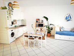 a kitchen and living room with a table and a couch at Almarea Beach - Essenza del mare, calore di casa in Imperia
