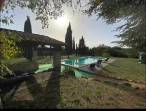 a swimming pool in a yard with a house at Joli 2 pièces dans maison au calme absolu in Saint-Julien