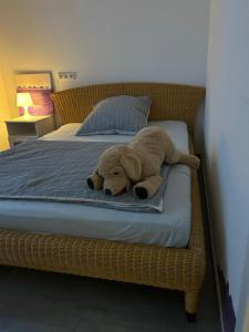 a stuffed teddy bear laying on a bed at Neue Erdgeschosswohnung in Zentrum von Rockenhausen in Rockenhausen