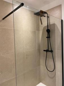 シント・トロイデンにあるVerliefd in Brustemのシャワーヘッド付きのガラスドアが備わるシャワールームです。