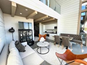 a living room with a couch and chairs and a table at Naava Chalet Loft - Kaksikerroksinen lasiseinähuoneisto järvinäköalalla in Ähtäri