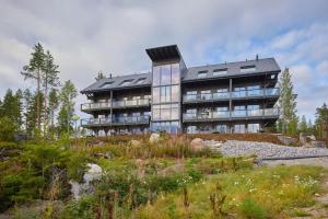 a large building on top of a hill with trees at Naava Chalet Loft - Kaksikerroksinen lasiseinähuoneisto järvinäköalalla in Ähtäri