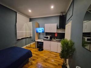 a room with a kitchen with a bed and a microwave at Dodi Aparts London, near Stratford close to tube station in London +62 photos
