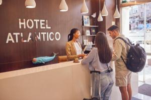 ビーゴにあるHotel Atlántico Vigoのホテルのカウンターの周りに立っている人々のグループ