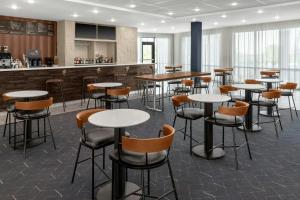 a restaurant with tables and chairs and a bar at Courtyard by Marriott Sherman in Sherman