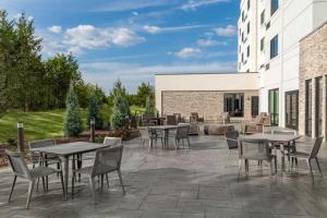 a patio with tables and chairs next to a building at Courtyard by Marriott Sherman in Sherman