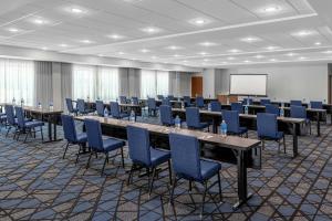 a conference room with long tables and blue chairs at Courtyard by Marriott Sherman in Sherman