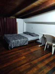 a bedroom with a bed and a desk and a table at Sobrado São Chico, Ubatuba SFS in São Francisco do Sul