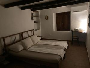 a bedroom with a bed in a room with a window at Nina's House , nonna Lucia in Badolato