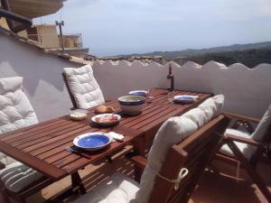 a wooden table and chairs on a balcony at Nina's House , nonna Lucia in Badolato