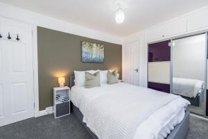 a bedroom with a large white bed and a window at Boddam getaway - CMC Stays in Boddam