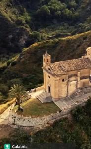 Nina's House , nonna Lucia في بادولاتو: مبنى قديم على تلة بها شجرة نخيل