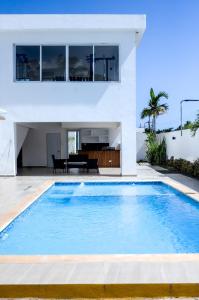 a villa with a swimming pool in front of a house at Apartamento amplio con piscina 