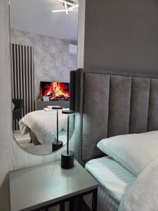 a bedroom with a bed and a fire in the fireplace at Apartman Elite Stay Doboj in Doboj