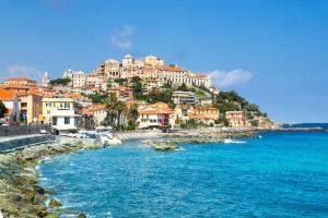 a group of buildings on a hill above the water at Almarea Beach - Essenza del mare, calore di casa in Imperia