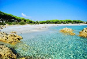 Una vista de una playa con rocas en el agua. en Residence con piscina a Sos Alinos, en Cala Liberotto 38 fotos más