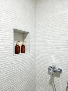 a bathroom with two soap bottles on a wall at Apartman Elite Stay Doboj in Doboj +15 photos