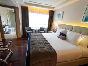 a hotel room with a large bed and a bathroom at Palladio Hotel Buenos Aires - MGallery Collection in Buenos Aires