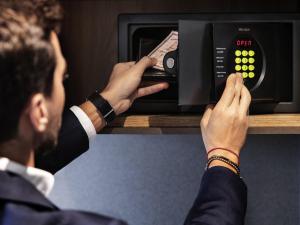 a man in a suit is adjusting a microwave oven at Novotel Parma Centro in Parma +149 photos