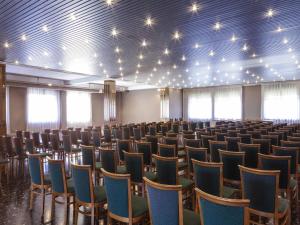 una habitación vacía con sillas y luces en el techo en ibis styles Trani, en Trani