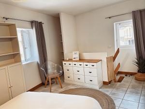 Un dormitorio con una cama y una cómoda y una ventana. en L'Ancien Moulin du Grand Annecy, en Annecy