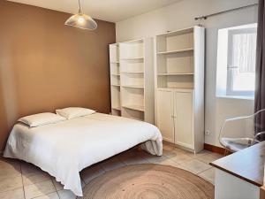 1 dormitorio con cama blanca y estanterías en L'Ancien Moulin du Grand Annecy, en Annecy