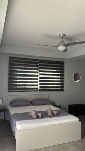 a bedroom with a white bed with a ceiling fan at ThaniaS'S Studio 1 in Tríkala