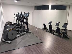 einen Fitnessraum mit einer Reihe von Heimtrainern in einem Zimmer in der Unterkunft Alojamiento Céntrico En Sonata Lomas Angelopolis in Lomas de Angelopolis