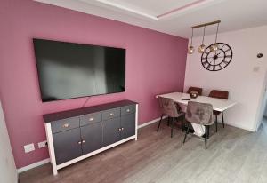 a dining room with a table and a large television on a wall at Jasmin's House, 2 bedroom, Private Parking in Northampton