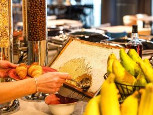 a person is preparing food on a counter with bananas at Mercure Bogota Calle 100 in Bogotá