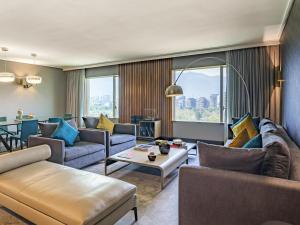 サンティアゴにあるPullman Santiago Vitacuraのソファとテーブルのあるリビングルーム