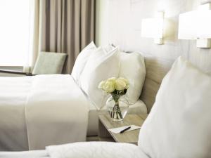 サンティアゴにあるPullman Santiago Vitacuraのベッドと花瓶のあるホテルの部屋 +175枚の写真