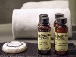 tre bottiglie di miele su un tavolo accanto a una saponetta di Pullman Santiago El Bosque a Santiago