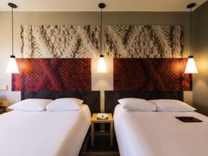 two beds sitting next to each other in a room at Ibis Torreon in Torreón