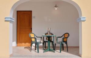 una mesa con sillas y una mesa con un jarrón. en Residence con piscina a Sos Alinos, en Cala Liberotto
