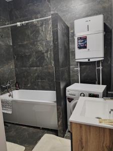 Un baño con lavabo, bañera e inodoro. en 24 home актау, en Aktau 3 fotos más