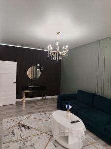 Una sala de estar con un sofá azul y una mesa. en 24 home актау, en Aktau