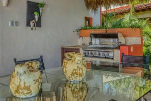 a glass table with two vases on top of it at Luxury Villa Paloma Blanca in Cruz de Huanacaxtle