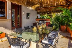 a patio with a glass table and chairs at Luxury Villa Paloma Blanca in Cruz de Huanacaxtle