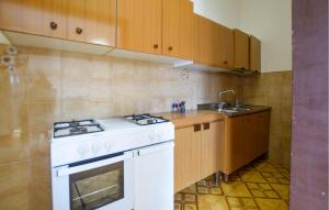 a kitchen with a white stove and a sink at 2 Bedroom Amazing Apartment In Casal Velino in Castellammare di Velia