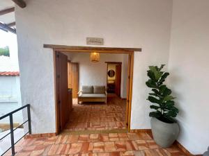 a hallway of a house with a couch and a plant at Casa Mónica Barichara in Barichara