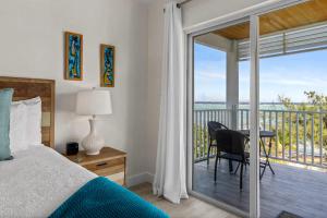 ein Schlafzimmer mit Bett und Balkon mit Aussicht in der Unterkunft The Blue Iguana at Cottages in Sand Bluff