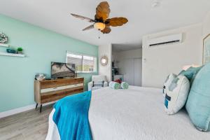 ein Schlafzimmer mit einem Bett und einem Deckenventilator in der Unterkunft The Blue Iguana at Cottages in Sand Bluff