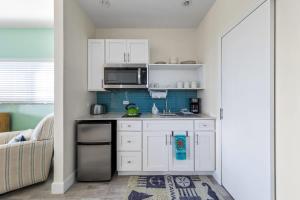 eine Küche mit weißen Schränken und einer Mikrowelle in der Unterkunft The Blue Iguana at Cottages in Sand Bluff