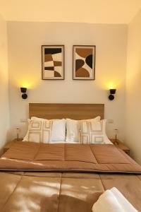 ein großes Bett in einem Schlafzimmer mit zwei Bildern an der Wand in der Unterkunft Hotel Aurelia Milano Centrale in Mailand