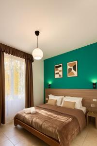 ein Schlafzimmer mit einem großen Bett mit einer grünen Wand in der Unterkunft Hotel Aurelia Milano Centrale in Mailand