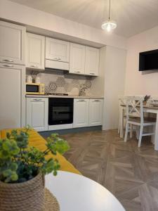 a kitchen with white cabinets and a table and a dining room at Guest House Teresina in San Giovanni in Fiore +9 photos