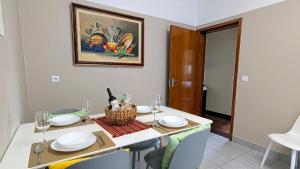 a dining room with a table with plates and wine glasses at Banana Lovers - Farm View in Ribeira Brava +11 photos