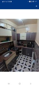 a small kitchen with a sink and a stove at Downtown Apartment in Aswan